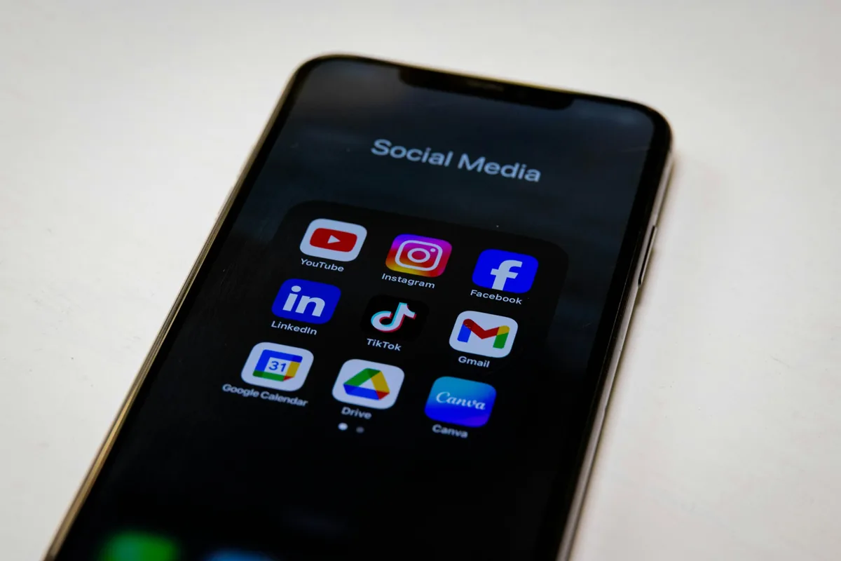 Smartphone displaying a folder titled "Social Media" with various popular app icons on a dark background
