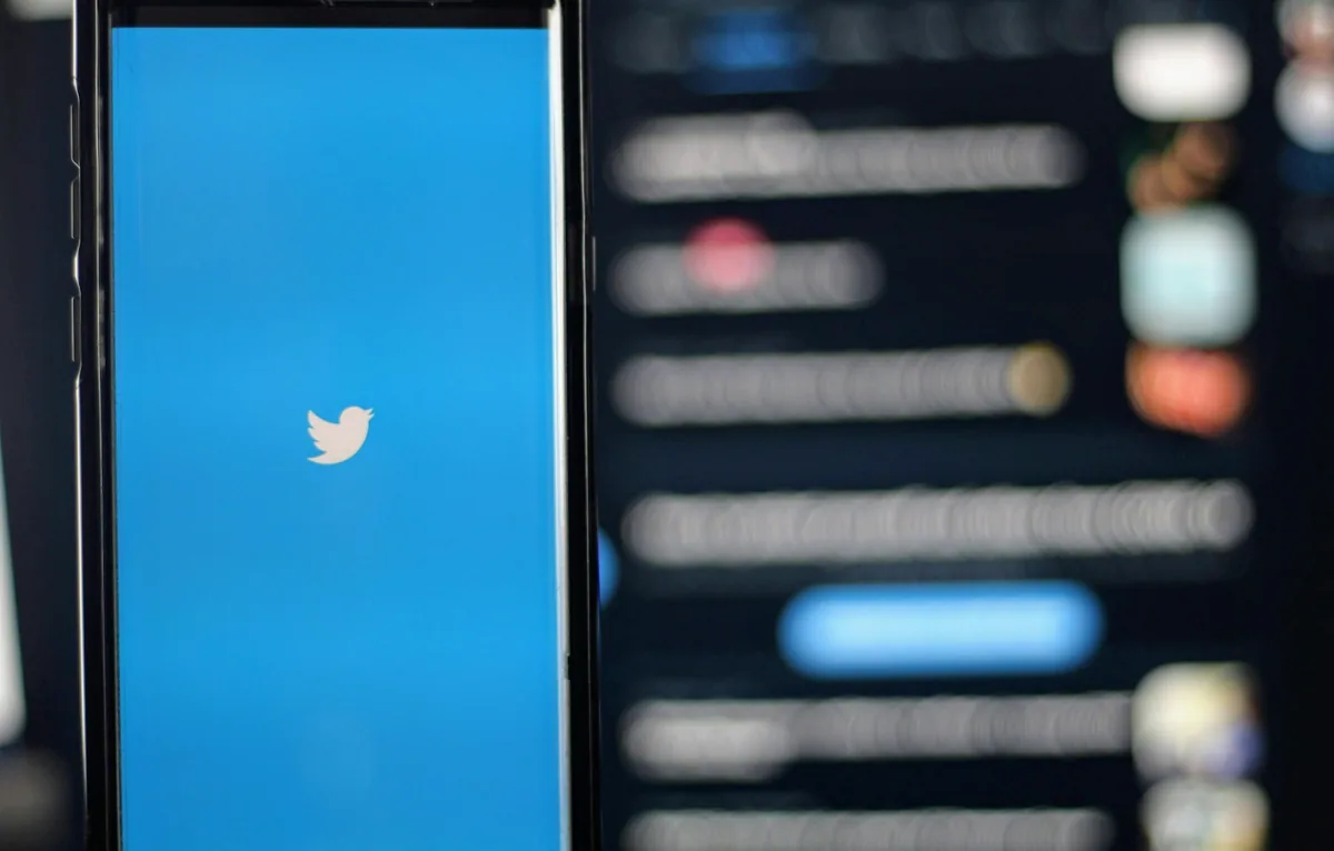 Smartphone displaying the white Twitter bird logo on a bright blue splash screen