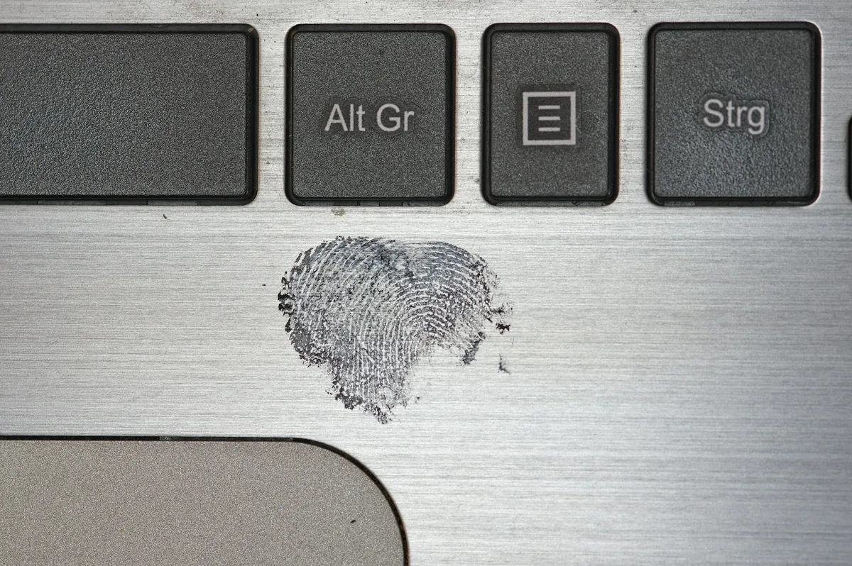 Heart-shaped fingerprint smudged on a silver laptop surface