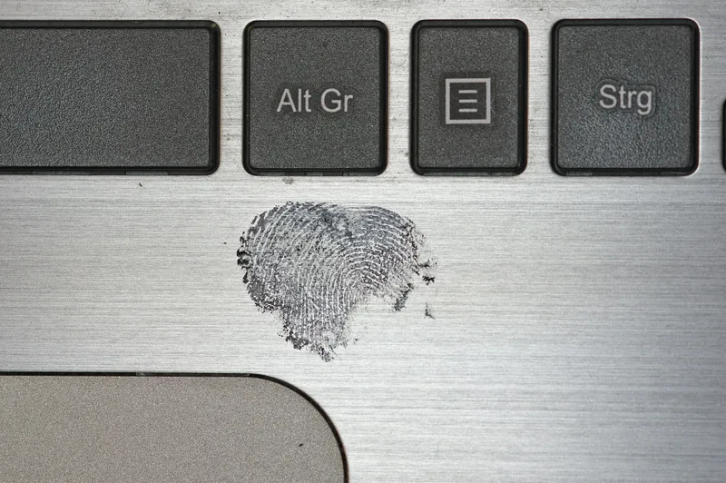 Heart-shaped fingerprint smudged on a silver laptop surface